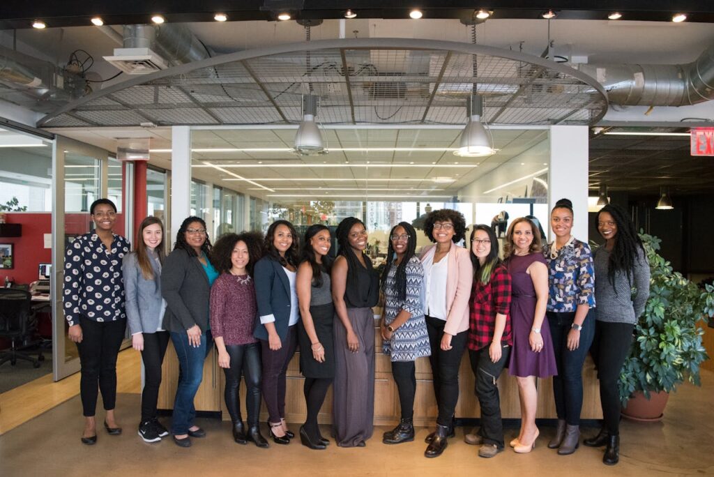 pexels photo 1181438 A diverse group of women in technology poses together in an office lobby, exuding confidence and teamwork.